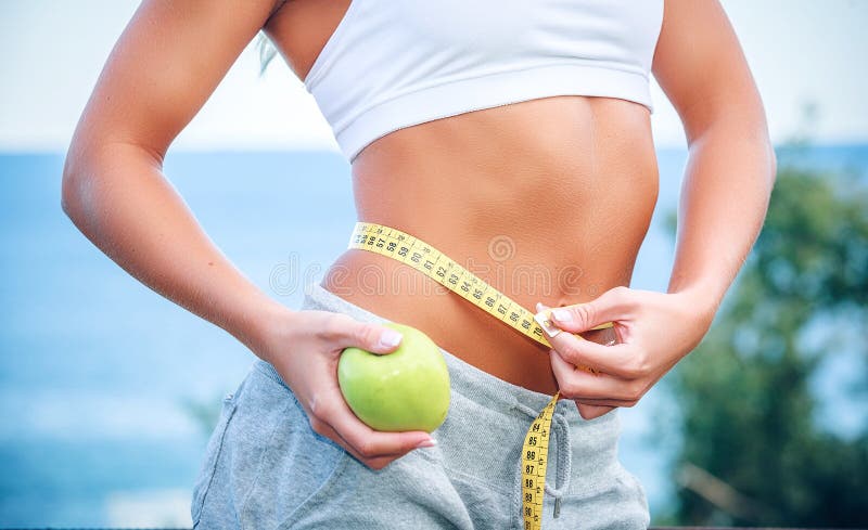 Torso of a young woman with an apple and meter