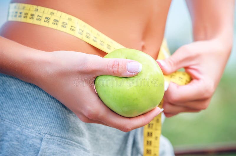 Torso of a young woman with an apple and meter