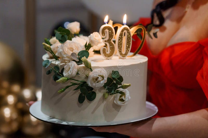 Tort elegant pentru ziua de naștere cu accente florale și lumânări aurite stock image