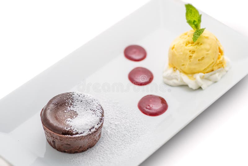Torta caliente del chocolate delicioso con la salsa de la fruta y el helado de vainilla en la placa blanca, pasta de azúcar del c imágenes de archivo libres de regalías Torta caliente del chocolate delicioso con la salsa de la fruta y el helado de vainilla en la placa blanca, pasta de azúcar del c imágenes de archivo libres de regalías
