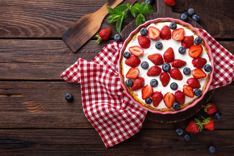 Torta deliziosa della fragola con il mirtillo fresco e la panna montata sulla tavola rustica di legno, torta di formaggio fotografia stock libera da diritti
