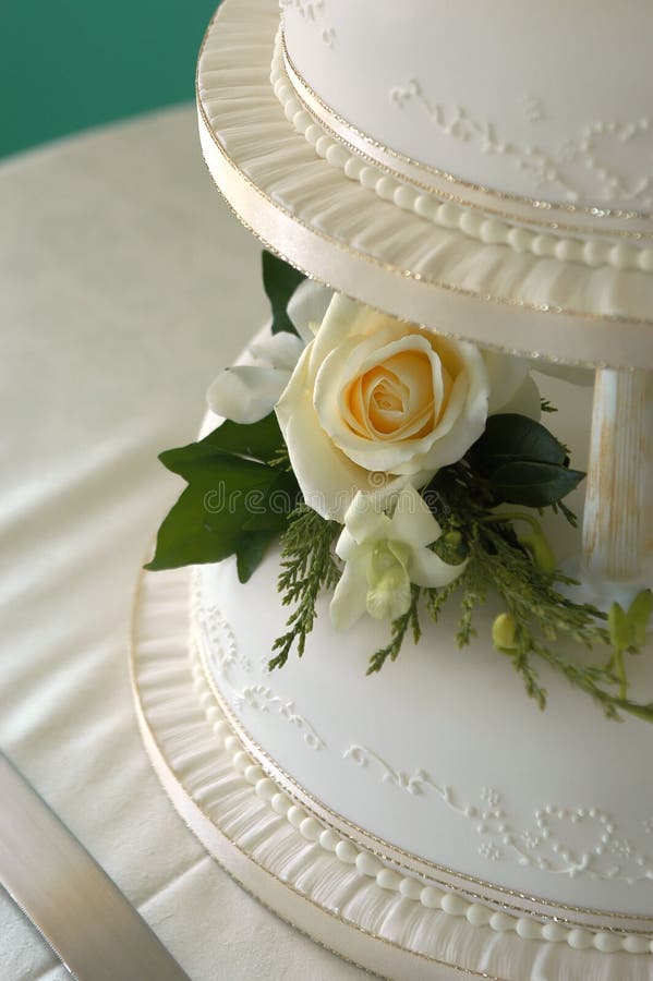 A traditional wedding cake with pillars and pale yellow rose. A traditional wedding cake with pillars and pale yellow rose