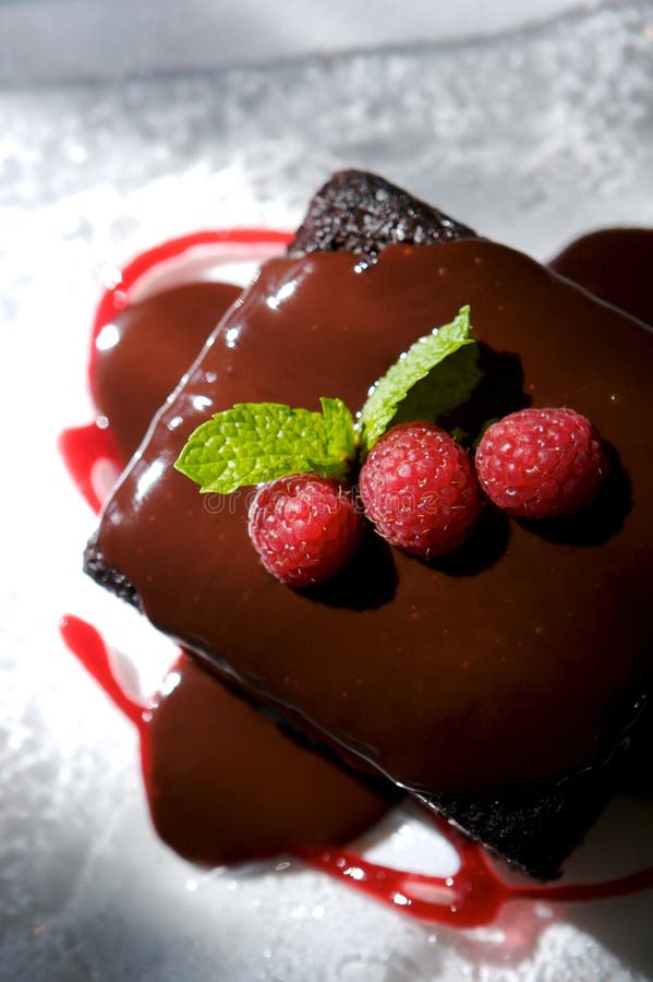 An image of decadent chocolate cake topped with raspberries. An image of decadent chocolate cake topped with raspberries