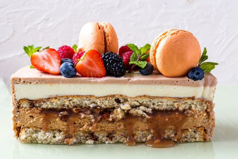 Torta hecha en casa con el macaron y fruta fresca, bayas en un fondo ligero foto de archivo Torta hecha en casa con el macaron y fruta fresca, bayas en un fondo ligero foto de archivo
