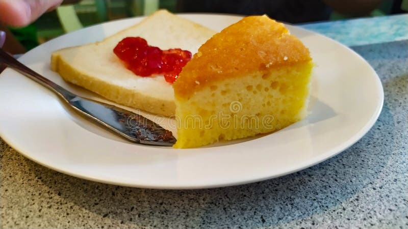 Torta y mermelada de fresa en el pan en el blanco del plato muy delicioso foto de archivo libre de regalías Torta y mermelada de fresa en el pan en el blanco del plato muy delicioso foto de archivo libre de regalías