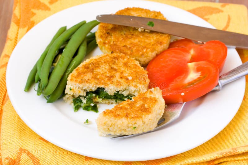 Quinoa Cakes with spinach served with beans and tomato. Quinoa Cakes with spinach served with beans and tomato