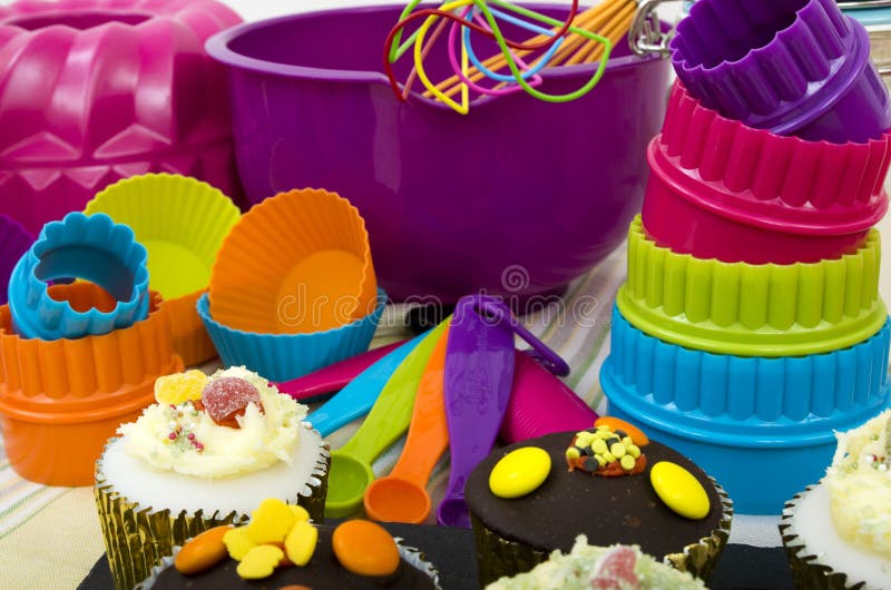 Image of Cup cakes with a selection of colorful cooking utensils. Image of Cup cakes with a selection of colorful cooking utensils