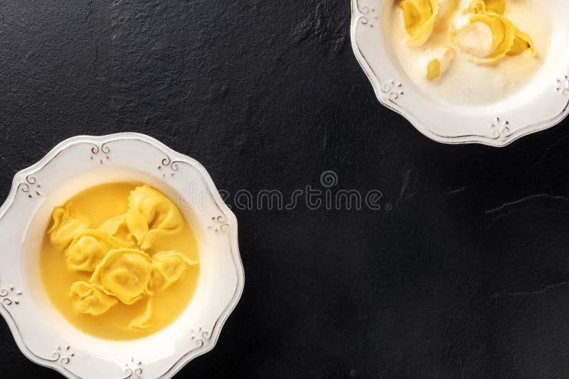 Tortellini con brodo e salsa alla crema cibi italiani su fondo nero con spazio fotografico