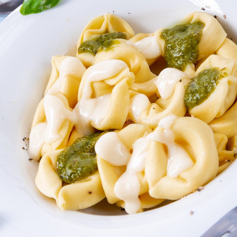 A Tortellini Di Formaggio with Basil Pesto and Cheese Sauce Stock Image
