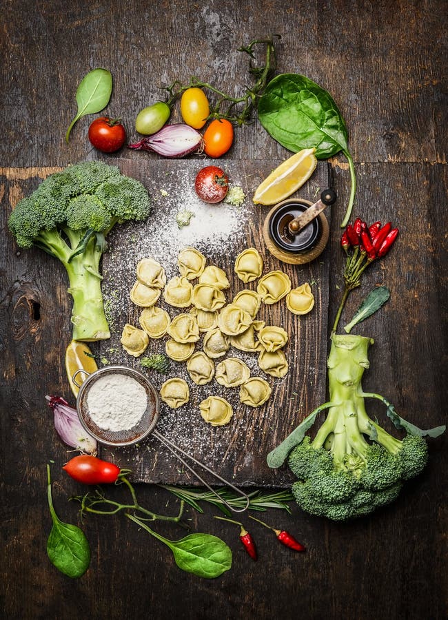 Tortellini with fresh vegetables , preparation with flour on rustic wooden background, top view. stock photography Tortellini with fresh vegetables , preparation with flour on rustic wooden background, top view. stock photography
