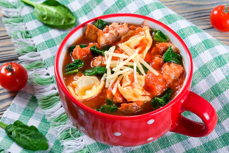 Tortellini polewka z włoskimi kiełbasami, szpinak, pomidor, parmesan ser zdjęcia stock Tortellini polewka z włoskimi kiełbasami, szpinak, pomidor, parmesan ser zdjęcia stock