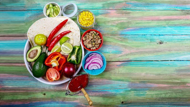 Tortiglii piane e varie verdure per i taci o il burrito che fanno sul fondo rustico, vista superiore, cucina messicana del confin fotografia stock Tortiglii piane e varie verdure per i taci o il burrito che fanno sul fondo rustico, vista superiore, cucina messicana del confin fotografia stock
