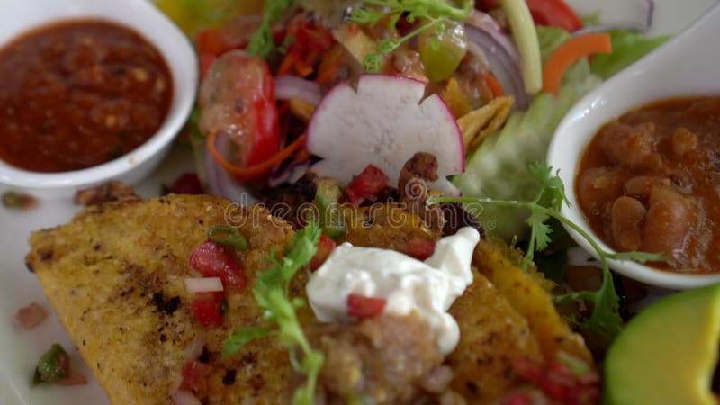 Tortilla de maïs taco à la salsa et à l'avocat assiette de salade fusion cuisine mexicaine banque de vidéos