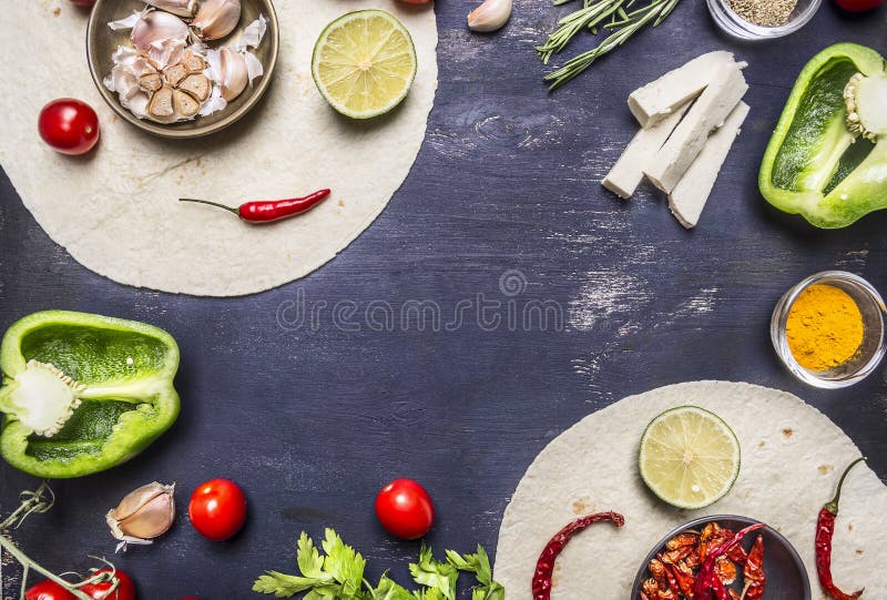 Tortilla with Ingredients for cooking vegetarian burrito with vegetables and lime on wooden rustic background top view close up w