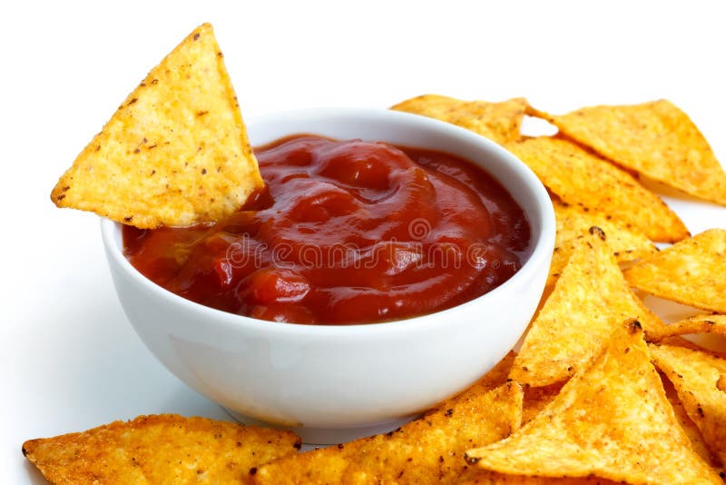 Round white bowl of tomato salsa dip surrounded with tortilla chips in perspective. Chip in dip. Round white bowl of tomato salsa dip surrounded with tortilla chips in perspective. Chip in dip.