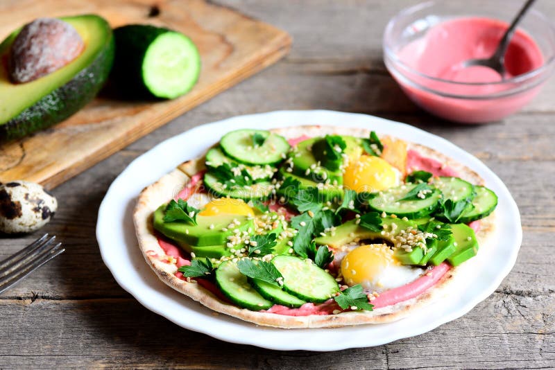 Tortilla wypiętrzał wysoko z, lathered z ćwikłowym hummus, i smażącymi przepiórek jajkami, avocado plasterkami, ogórkiem, sezamem zdjęcia stock Tortilla wypiętrzał wysoko z, lathered z ćwikłowym hummus, i smażącymi przepiórek jajkami, avocado plasterkami, ogórkiem, sezamem zdjęcia stock