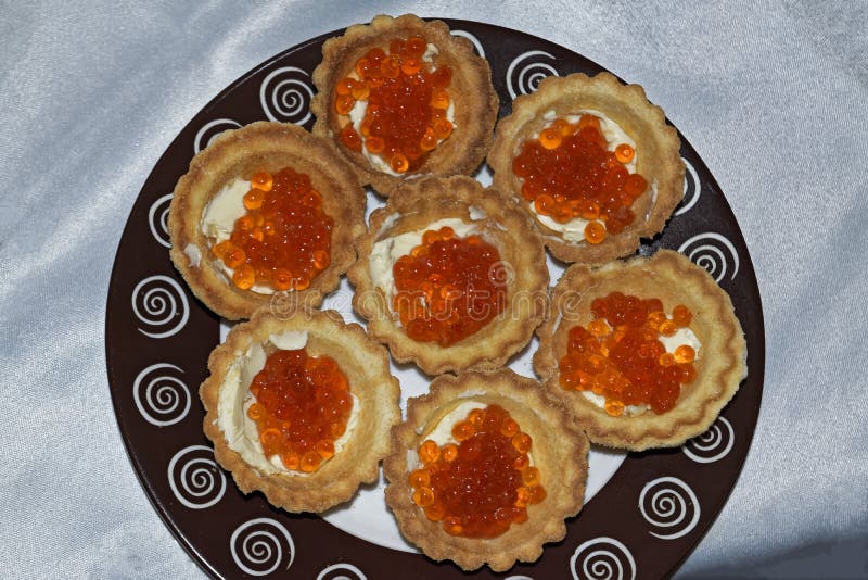 Tortini con la fine rossa del caviale su delicatessen Alimento gastronomico Struttura del caviale fotografia stock Tortini con la fine rossa del caviale su delicatessen Alimento gastronomico Struttura del caviale fotografia stock