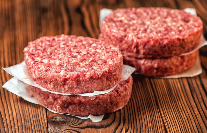 Tortini crudi dell'hamburger della carne della carne tritata su carta
