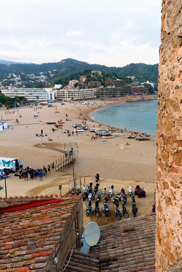 Tossa de Mar Catalonia, Spanien, Augusti 2018 Strand, hav, turister och avlägsna berg på solnedgången, sikten från väggen av fet arkivfoton Tossa de Mar Catalonia, Spanien, Augusti 2018 Strand, hav, turister och avlägsna berg på solnedgången, sikten från väggen av fet arkivfoton