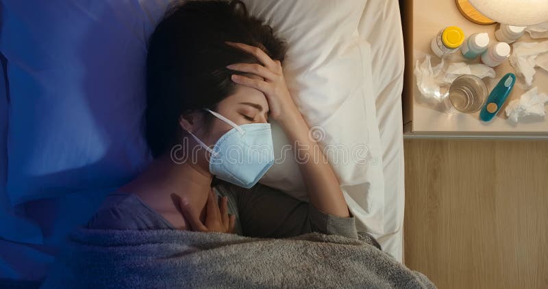 Tosse femminile asiatica in camera da letto fotografia stock