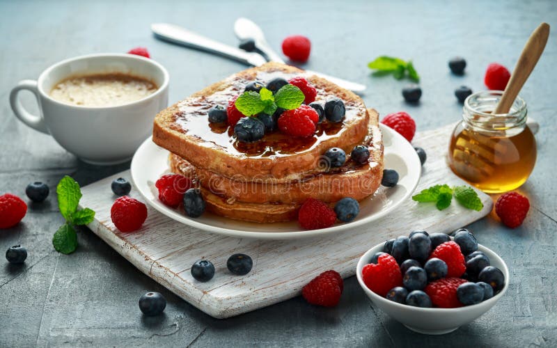Tostada de canela francesa con los arándanos, las frambuesas, el jarabe de arce y el café Desayuno de la mañana foto de archivo libre de regalías Tostada de canela francesa con los arándanos, las frambuesas, el jarabe de arce y el café Desayuno de la mañana foto de archivo libre de regalías