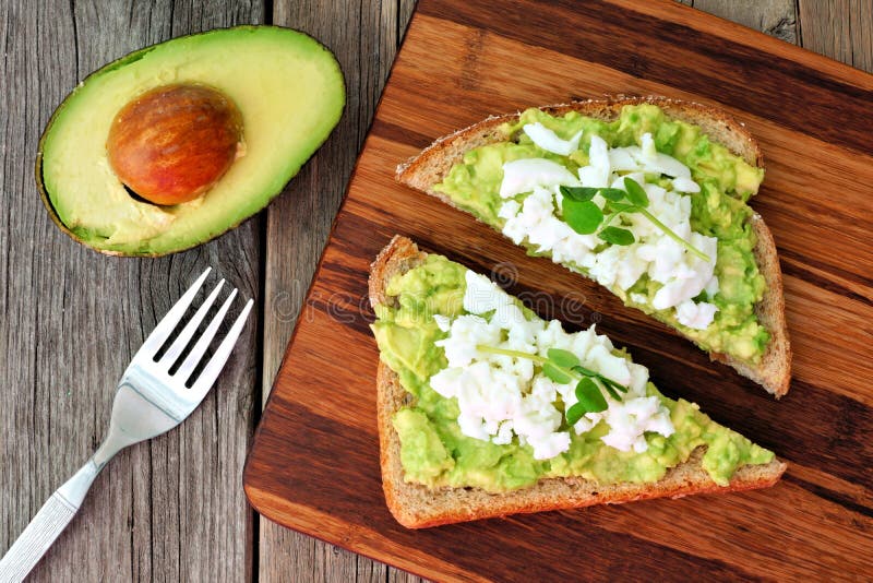 Tostada del aguacate con las claras de huevo y los lanzamientos del guisante, visión de arriba fotografía de archivo Tostada del aguacate con las claras de huevo y los lanzamientos del guisante, visión de arriba fotografía de archivo