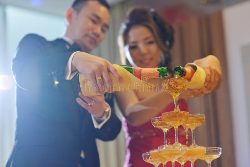 Asian Chinese wedding dinner reception, bride and groom champagne toasting, natural candid photo. Asian Chinese wedding dinner reception, bride and groom champagne toasting, natural candid photo.