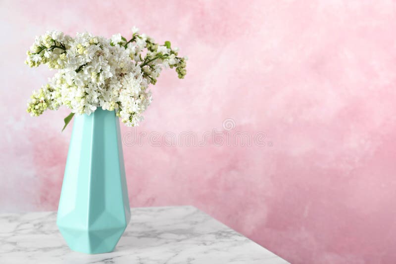 Tot bloei komende lilac bloemen in vaas op marmeren lijst tegen kleurenachtergrond royalty-vrije stock afbeeldingen Tot bloei komende lilac bloemen in vaas op marmeren lijst tegen kleurenachtergrond royalty-vrije stock afbeeldingen