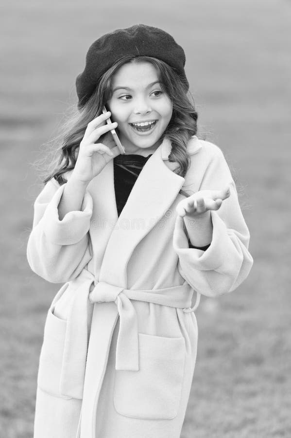 Totally happy. fall season. happy childhood. small child with phone. beauty in autumn coat. cheerful little girl in stock image Totally happy. fall season. happy childhood. small child with phone. beauty in autumn coat. cheerful little girl in stock image
