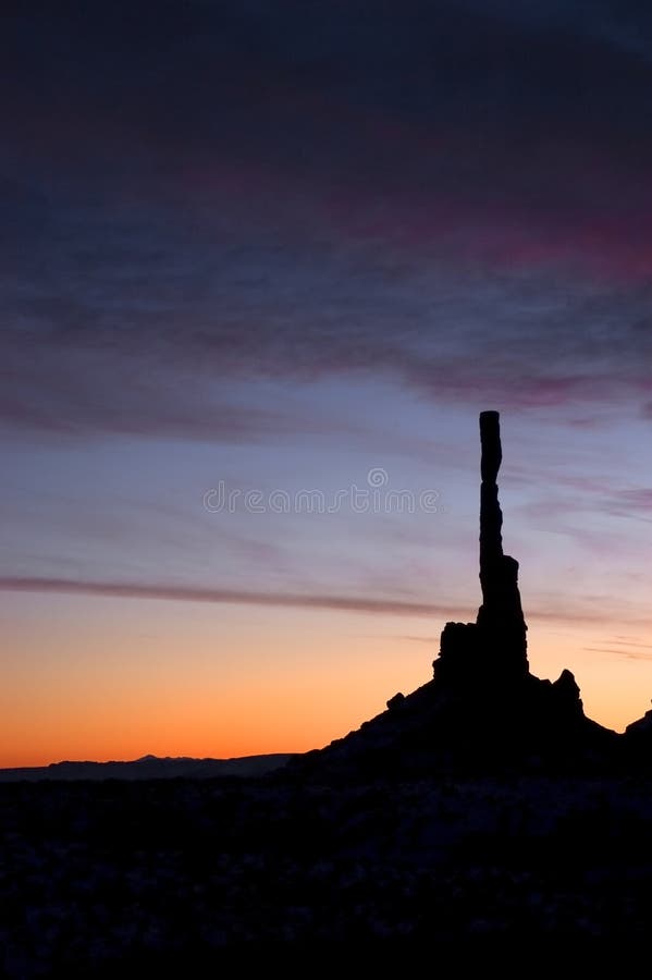 Monument Vally Navajo Tribal Park Totem Pole Monolith sunrise with the Totem Pole captured in a silhouette. The Totem pole is one of many monolith rock formations throughout the region, making fro a stunning landscape, especially with the colors from the rising sun and clouds. American southwest. Monument Vally Navajo Tribal Park Totem Pole Monolith sunrise with the Totem Pole captured in a silhouette. The Totem pole is one of many monolith rock formations throughout the region, making fro a stunning landscape, especially with the colors from the rising sun and clouds. American southwest.