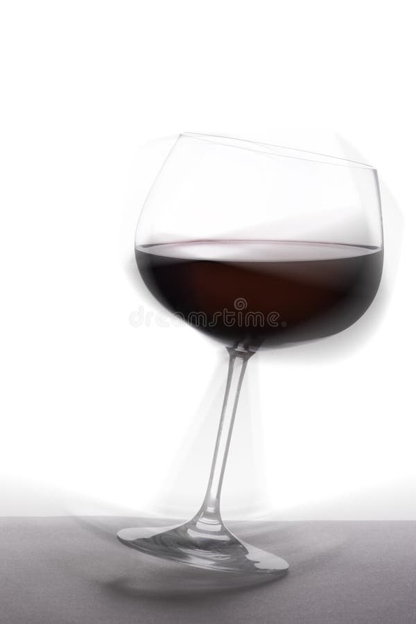 Tottering glass of red wine royalty free stock photos