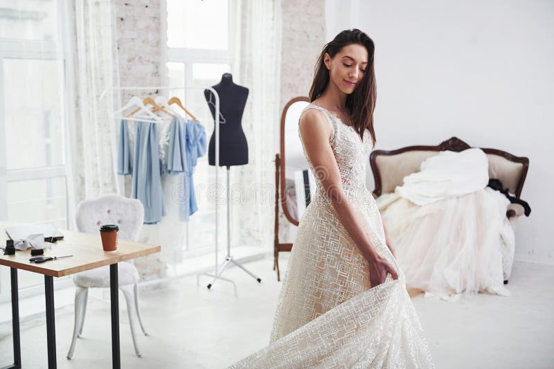 Caucasian female costume designer works on wedding gown - Stock Image -  Everypixel