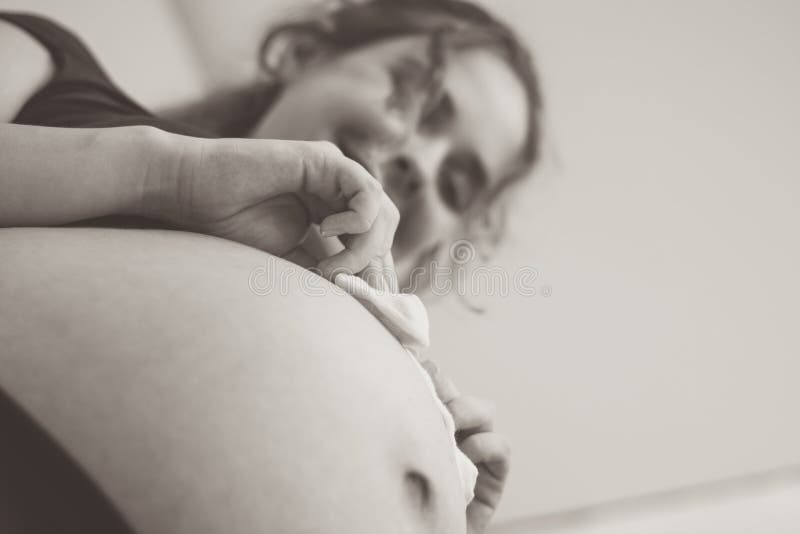 Touching Photo of Pregnancy Moments Young Expectant Mother with Socks on  Her Belly Stock Photo - Image of home, baby: 235027590