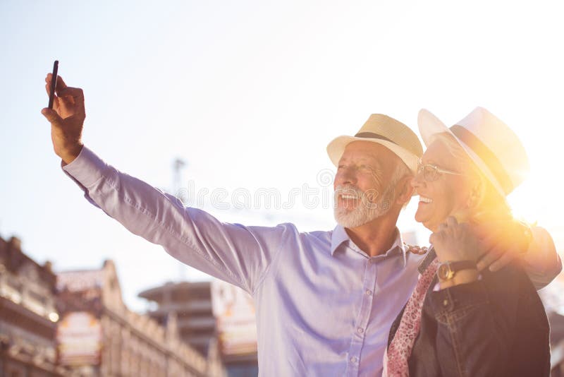 Tourism and technology. Traveling senior couple taking selfie together against sightseeing background. stock image Tourism and technology. Traveling senior couple taking selfie together against sightseeing background. stock image