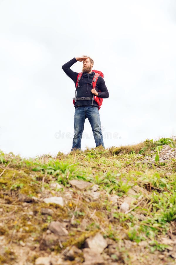 Tourist with beard and backpack looking far away