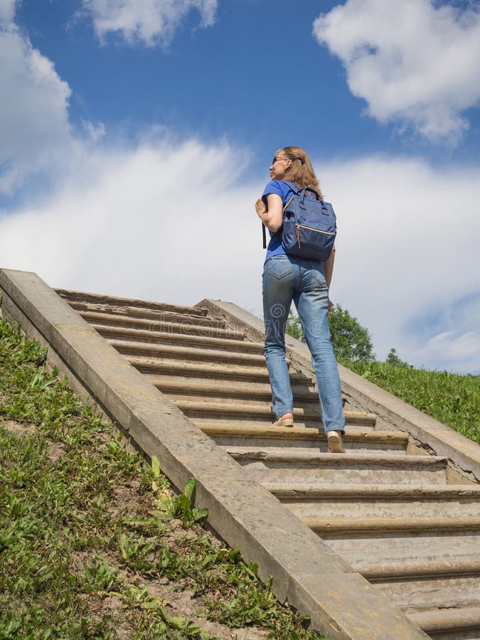 tourist poses for a photo on a sky stairway