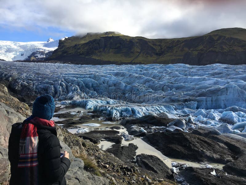 Tourist, der Svinafellsjokull-Gletscher beim Island-Zurücktreten betrachtet stockfotos Tourist, der Svinafellsjokull-Gletscher beim Island-Zurücktreten betrachtet stockfotos