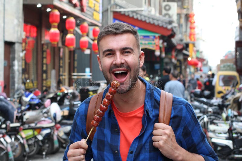 Tourist eating Bing Tanghulu Candied Hawthorn Stick