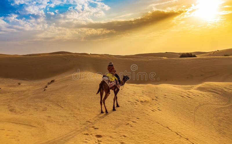 Tourist enjoy desert safari camel ride at Thar desert Jaisalmer, Rajasthan, India.