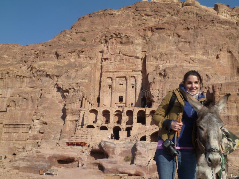 Tourist girl holding donkey in Petra Jordan