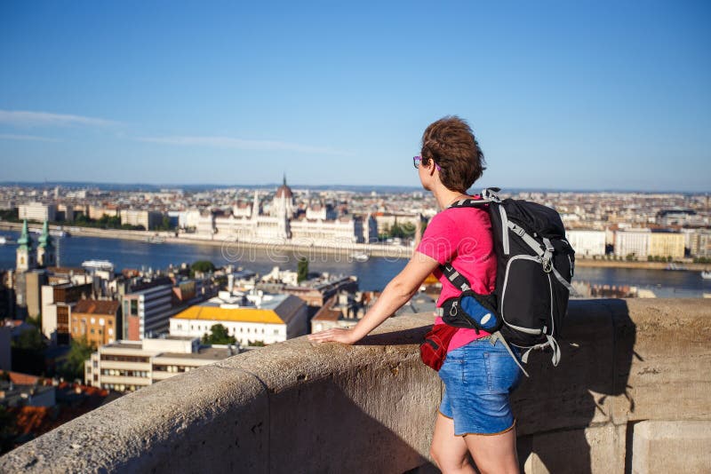 A tourist girl is standing with her back in the observation deck at the altitude overlooking the parliament in Hungary, Budapest c royalty free stock photography A tourist girl is standing with her back in the observation deck at the altitude overlooking the parliament in Hungary, Budapest c royalty free stock photography