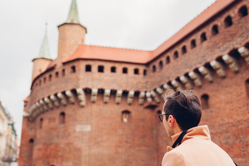 Tourist looking at Barbikan gate in Krakow city  Poland. Barbakan museum. Man traveler enjoys sightseeing