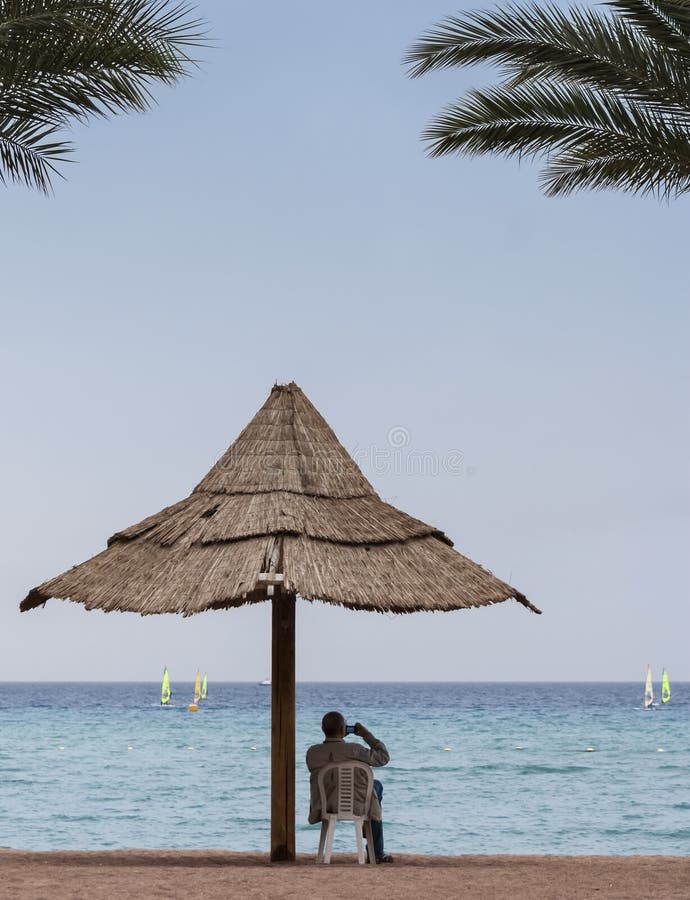 Tourist is resting on the central beach of Eilat stock photo Tourist is resting on the central beach of Eilat stock photo