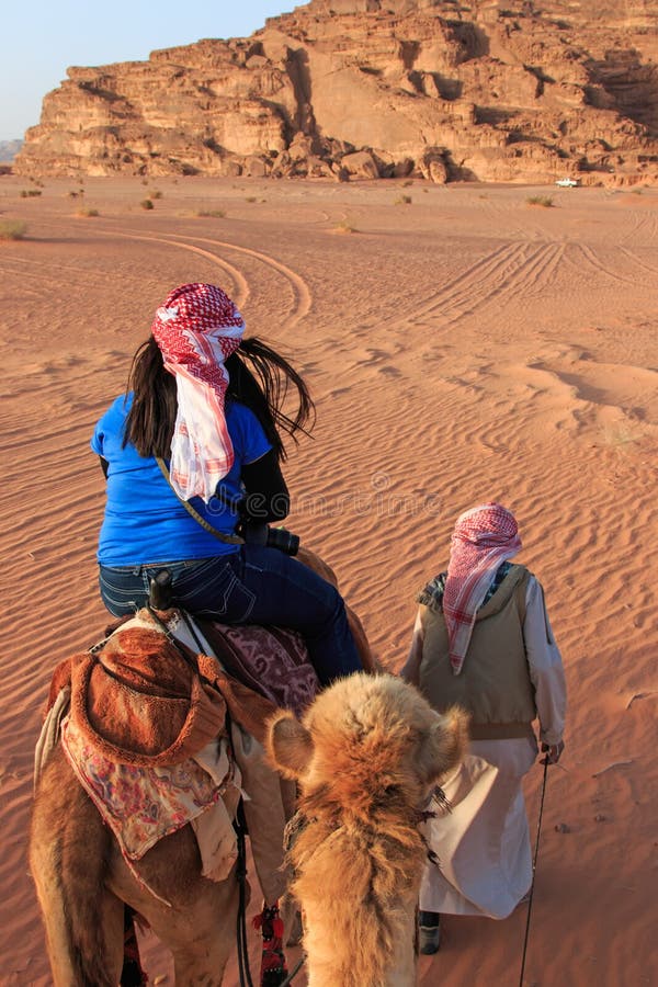 Tourist riding a camel at sunset in the Wadi Rum desert, Jordan stock image Tourist riding a camel at sunset in the Wadi Rum desert, Jordan stock image