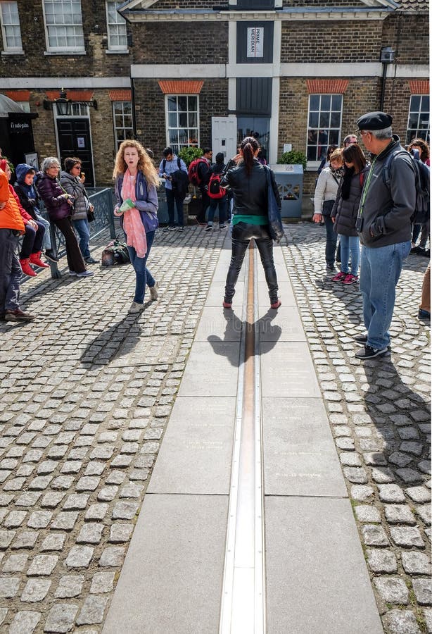 Tourist stand between east and west of prime meridian line in Royal Observatory Greenwich . Greenwich is notable for its name to t