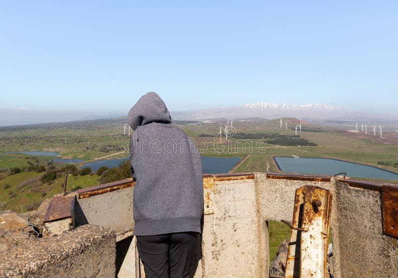 A tourist stands in the remnant of a concrete trench at a former defensive post on Mount Bental, looking at the surroundings in the Golan Heights in northern Israel. A tourist stands in the remnant of a concrete trench at a former defensive post on Mount Bental, looking at the surroundings in the Golan Heights in northern Israel