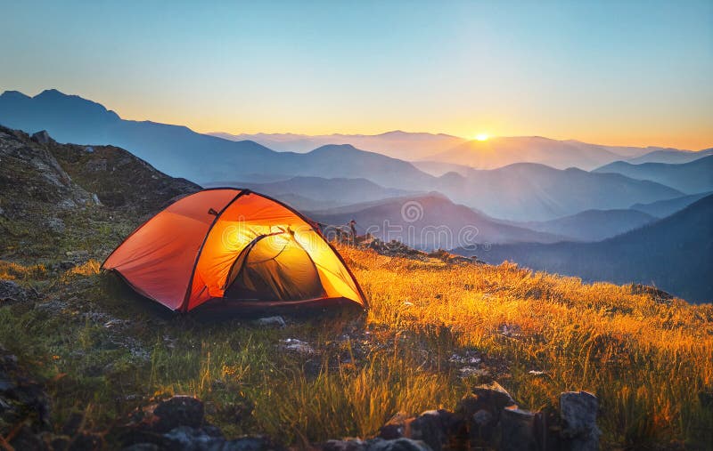 Tourist tent camping in mountains at sunset