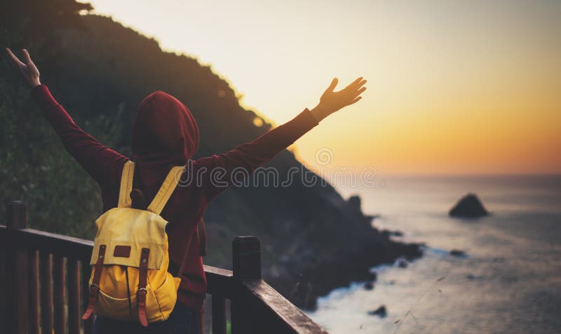 Tourist traveler with backpack standing with raised hands, hiker looking on sunset to valley in trip, hipster young girl enjoying stock photos Tourist traveler with backpack standing with raised hands, hiker looking on sunset to valley in trip, hipster young girl enjoying stock photos