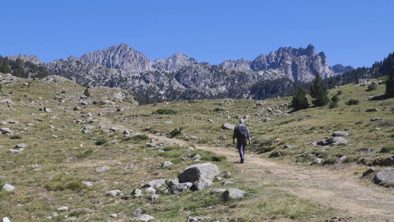 Tourist walking on Spanish Pyrenees Mountain in a sunny day