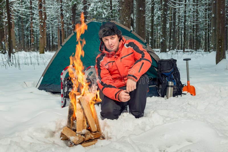 A tourist in a winter forest in extreme conditions is building a